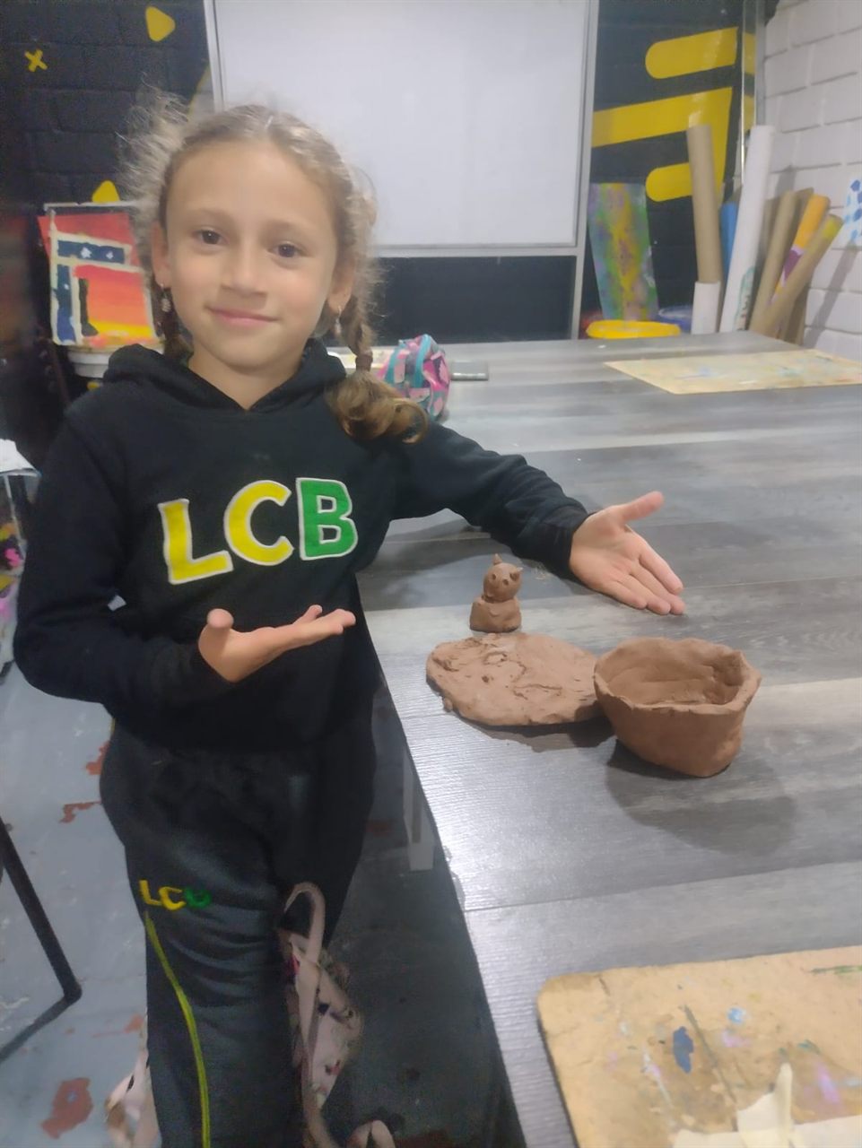 Niña con sus esculturas en arcilla