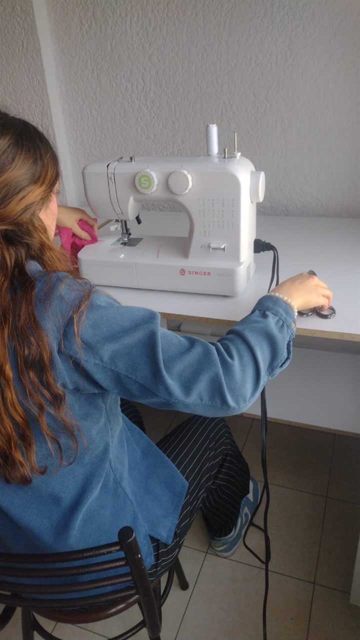 Estudiante cosiendo, taller de diseño de modas